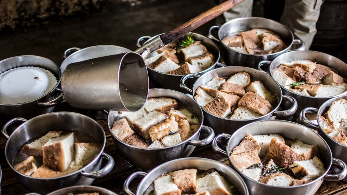 A rustic kitchen scene with pots of traditional bread soup being prepared in the Azores.